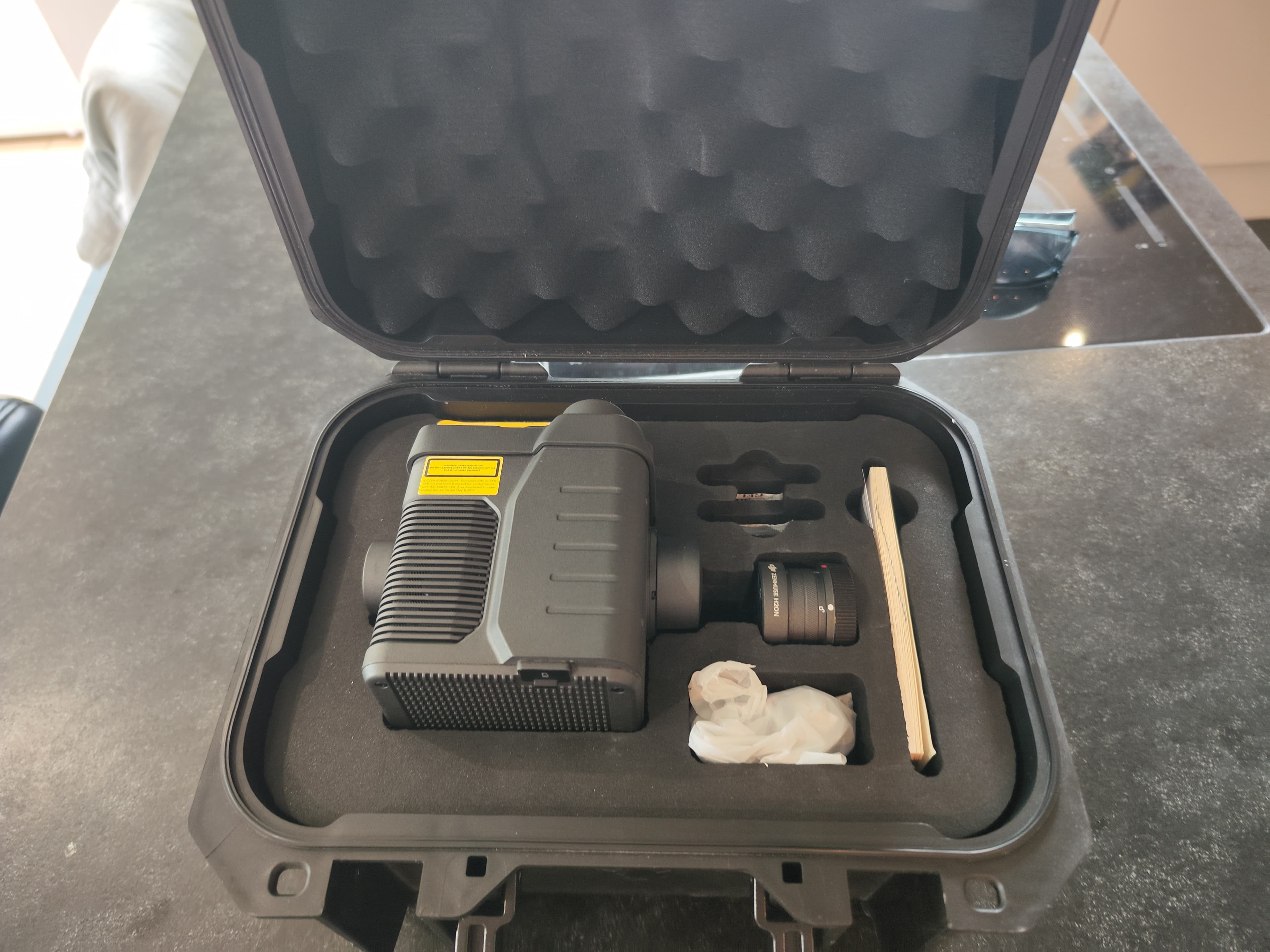Offener schwarzer Schutzkoffer mit Schaumstoffeinlage, der eine DJI Zenmuse H20N Kamera und Zubehör enthält.