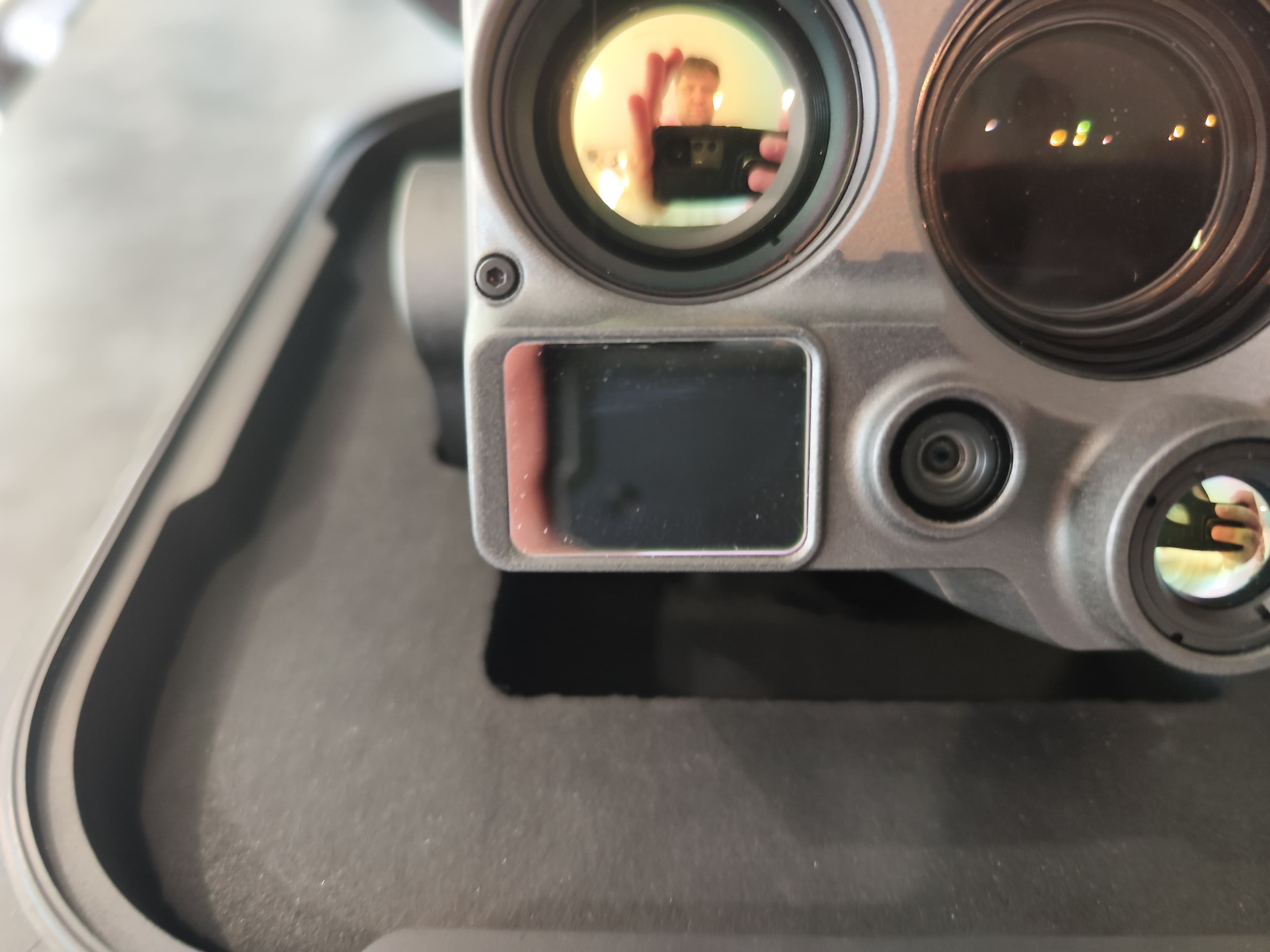 Nahaufnahme einer grauen Multisensor-Kamera mit mehreren Linsen, eingebettet in einer schwarzen Schaumstoffeinlage eines Transportkoffers.